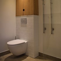 ​Badmøbel over hængetoilet. Ved en badeværelsesrenovering har vi leveret et specialfremstillet badeværelsesmøbel, der udnytter pladsen over den lille væg der bærer hængetoilettet.