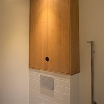 Badmøbel over hængetoilet. Ved en badeværelsesrenovering har vi leveret et specialfremstillet badeværelsesmøbel, der udnytter pladsen over den lille væg der bærer hængetoilettet.