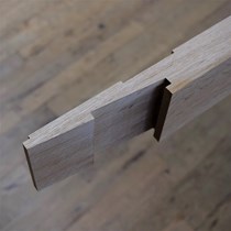 ​Snedkersamling på et karmstykke til en buet egetræsdør. Samlingen mellem sidekarm og buet overkarm udføres på traditionel vis med en trælås der kiles sammen.
