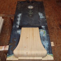 En dør til et bondehus er nænsomt restaureret ved partiel udskiftning af råddent træ. Døren er inspireret i Rokokostil med svulmende fyldning i nedre del.