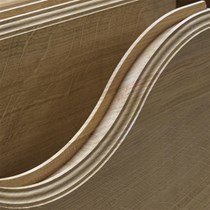 Specialfremstillet træværk. Her et foto af en dørdetalje i form af et buet rammestykke til en massiv trædør.