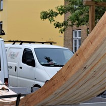 Buede bjælker klar til at forlade tømmerpladsen. Vi har tildannet spander eller riber til forstærkning af den bærende trækonstruktion for et hvælvet loft nedbrudt af borebiller.